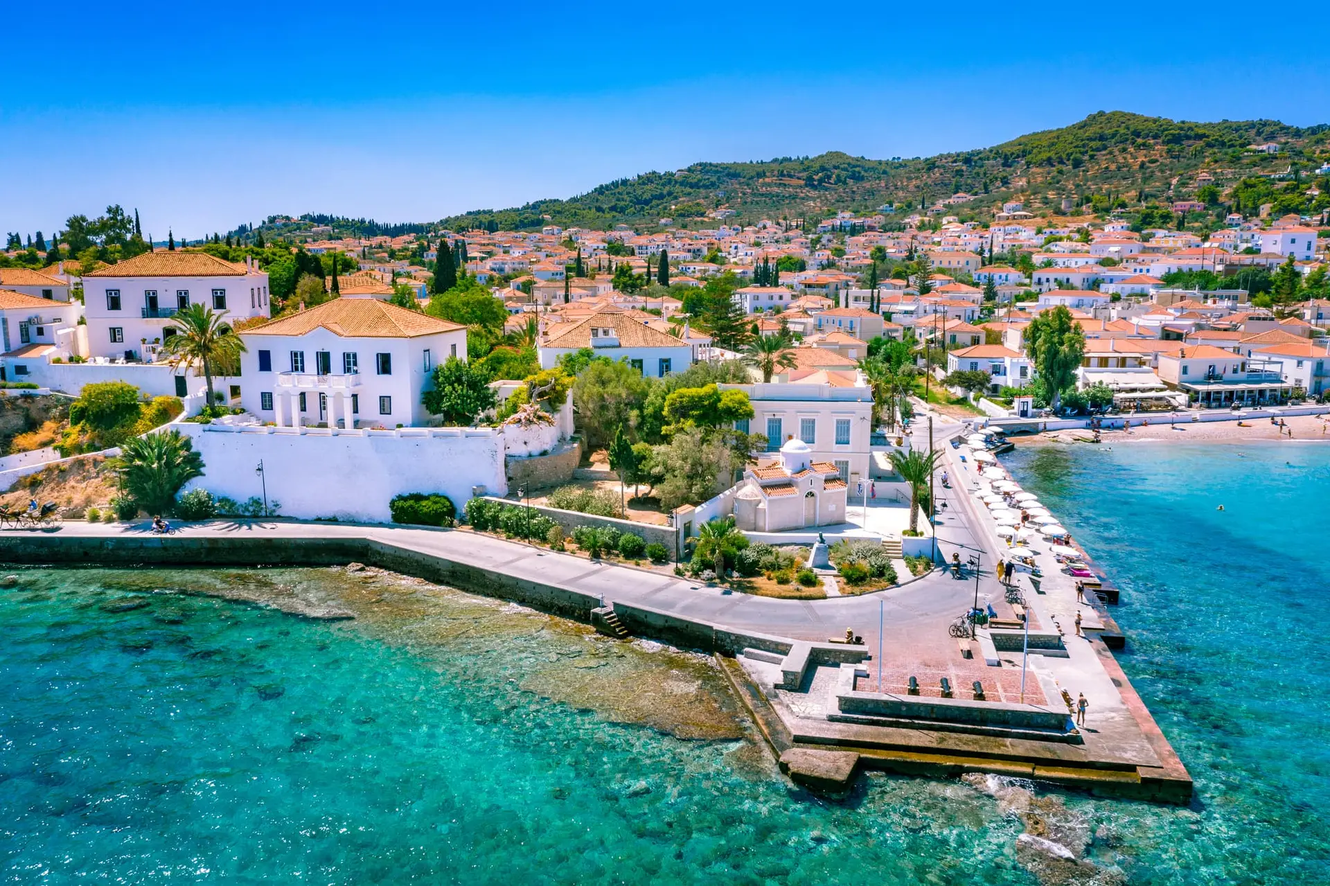 Turquoise waters and neoclassical architecture in Spetses, Greece.