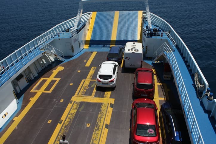 Auto parcheggiate sul ponte di un traghetto durante la traversata in mare.