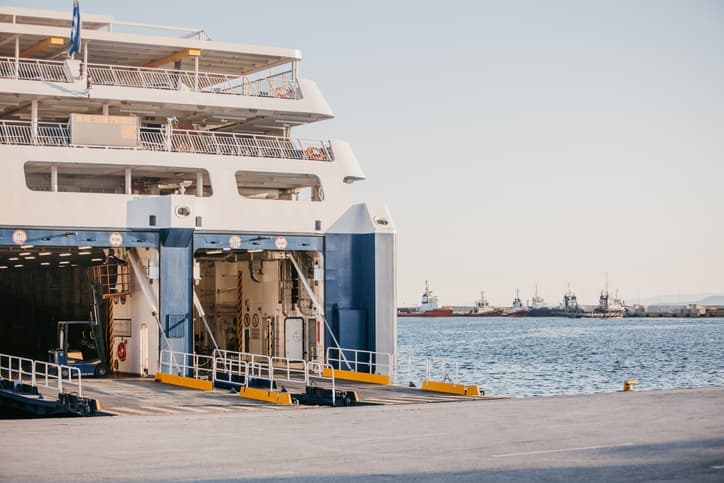 Traghetto in porto con rampa aperta per l’imbarco auto.