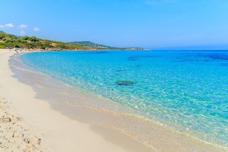 Spiaggia di Saleccia in Corsica con sabbia bianca e mare turchese, immersa in un paesaggio naturale incontaminato.