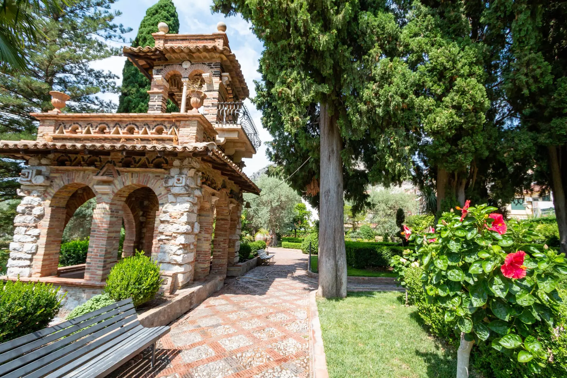 Une construction ancienne méditerranéenne dans un beau jardin en fleurs.