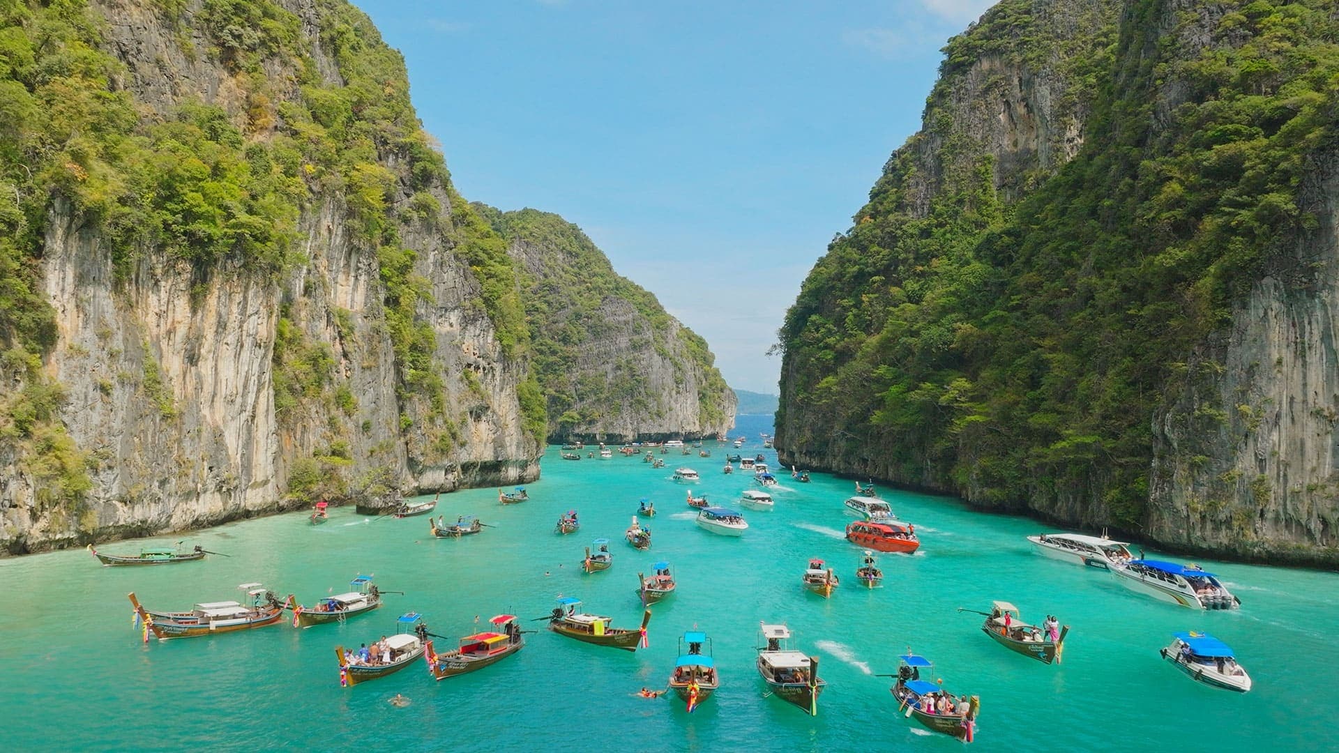 The crisp blue waters of Thailand's Phi Phi island are dotted by small boats.
