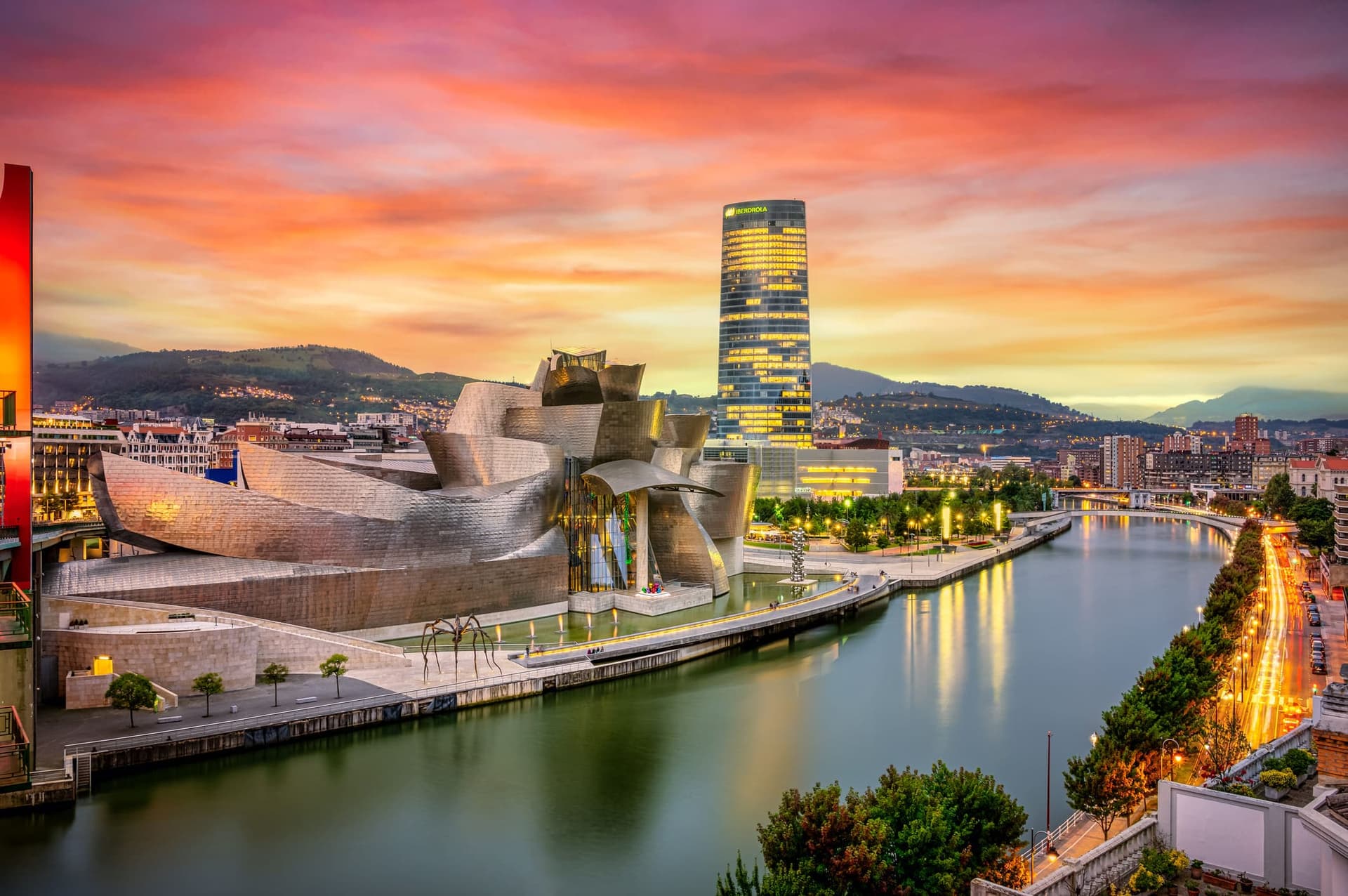 The cityscape of Bilbao at sunset, Spain. The Nervion river crosses Bilbao downtown, hosting in its margins the traditional and modern buildings of the city with Guggenheim museum and Iberdrola tower.