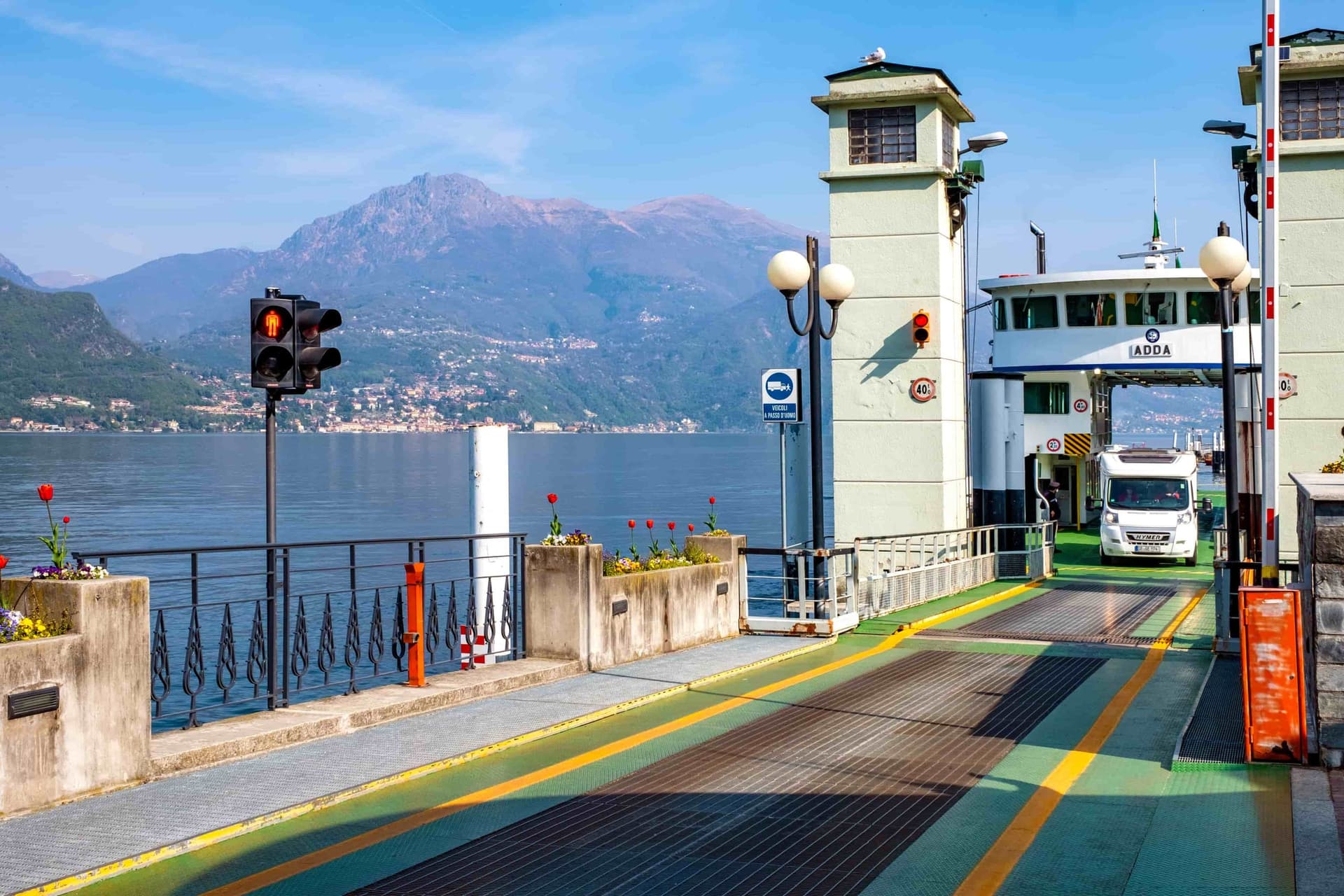 Un lac italien où accoste un bac transportant un camping-car