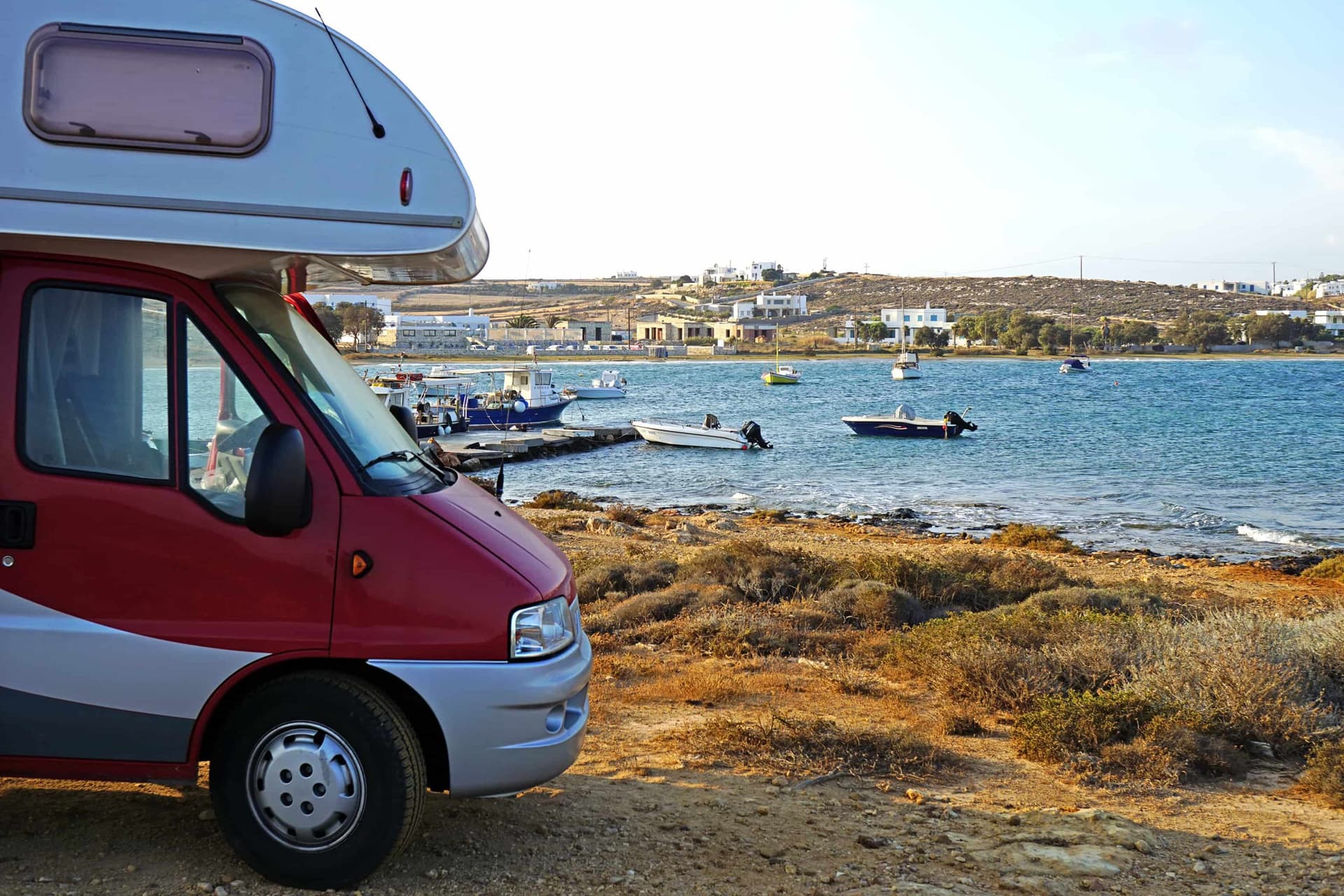 Un camping-car rouge devant la plage de Naoussa, sur l'île grecque de Paros