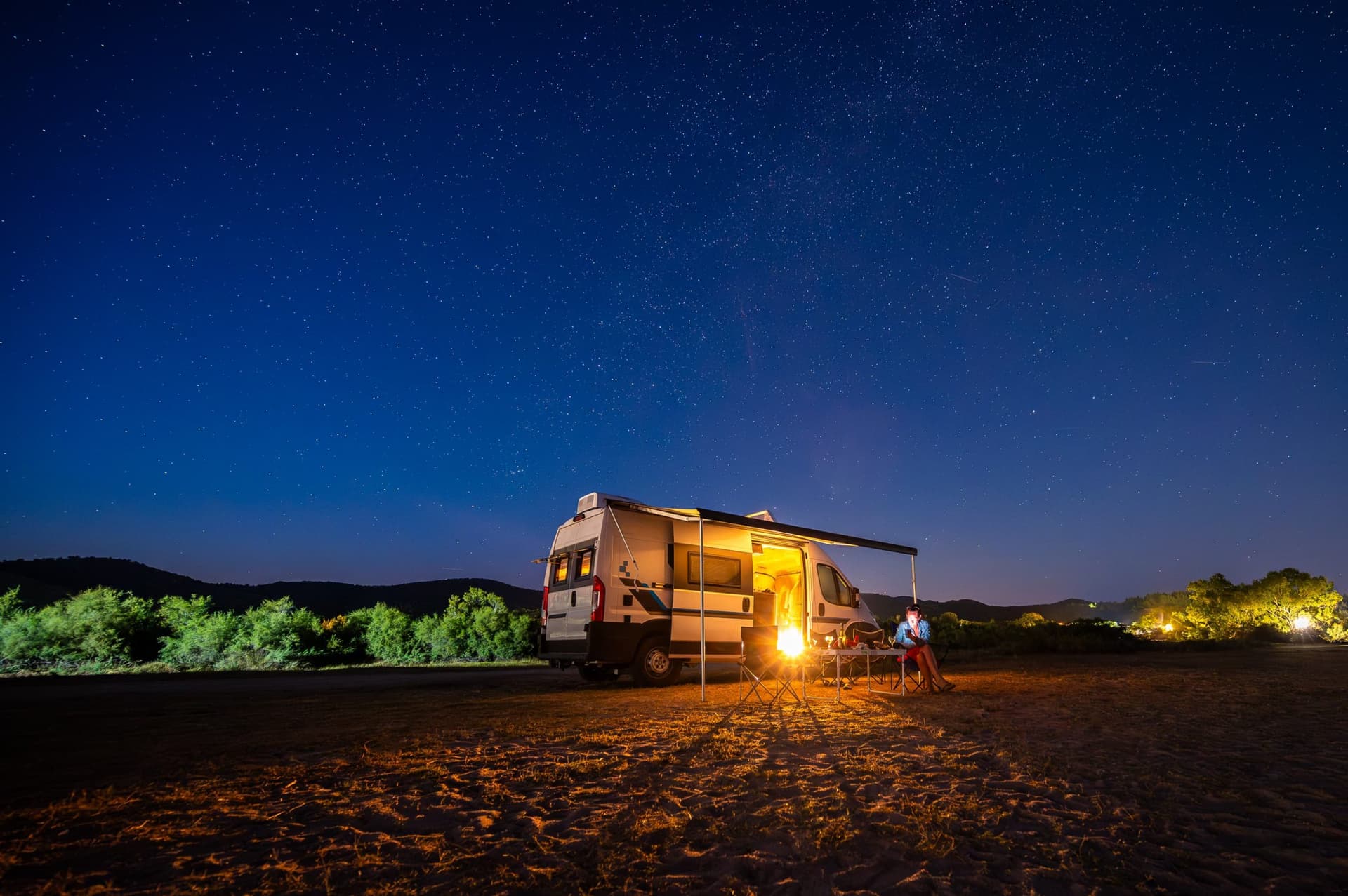 Un campement avec un camping-car sous les étoiles sur une plage grecque