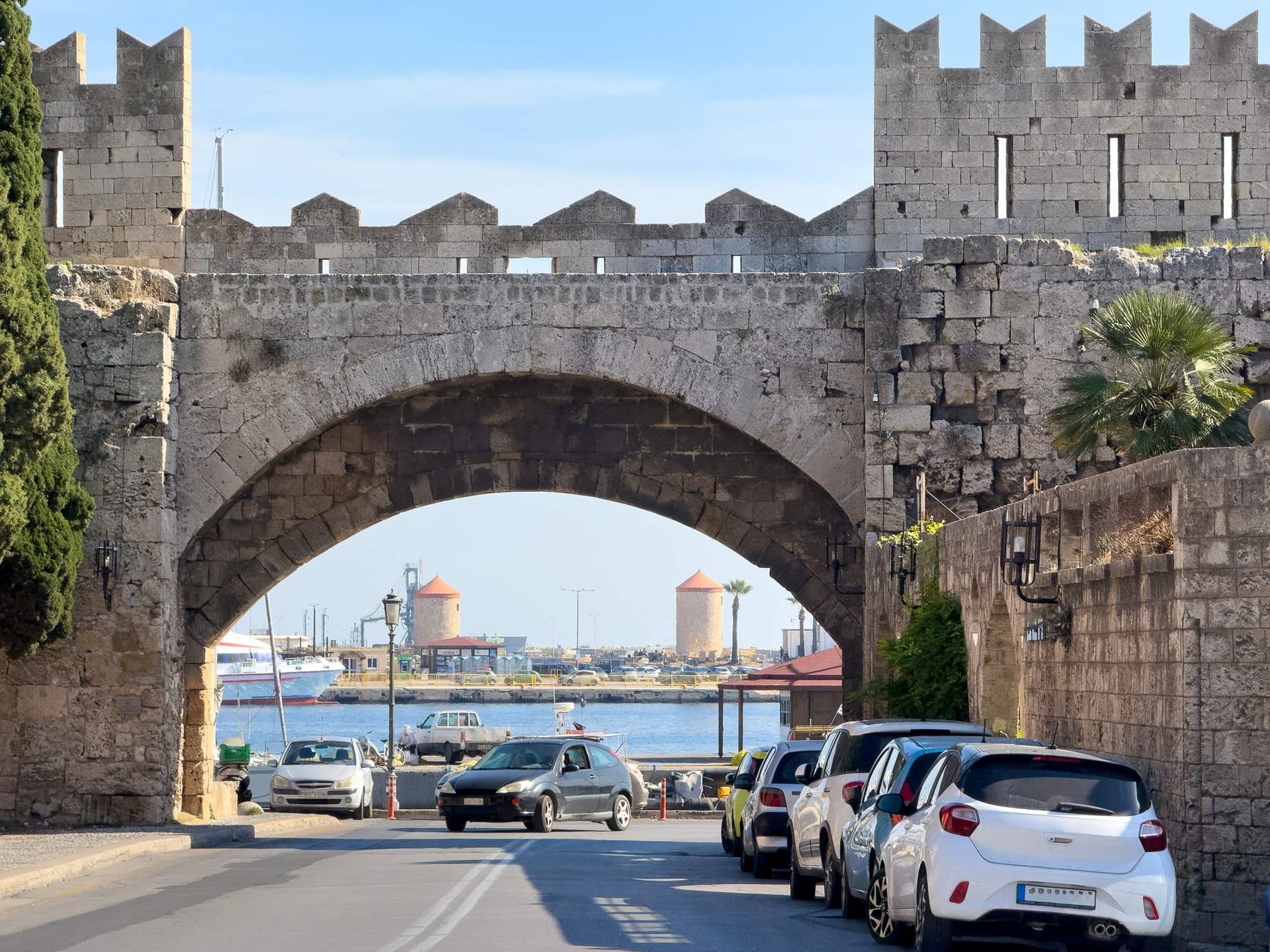 The Medieval Old Town gate of Rhodes, Greece frames the harbour.