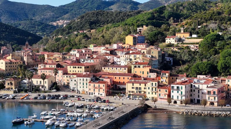 Case colorate e porticciolo di Rio Marina, Isola d'Elba, ai piedi delle colline verdi della costa orientale