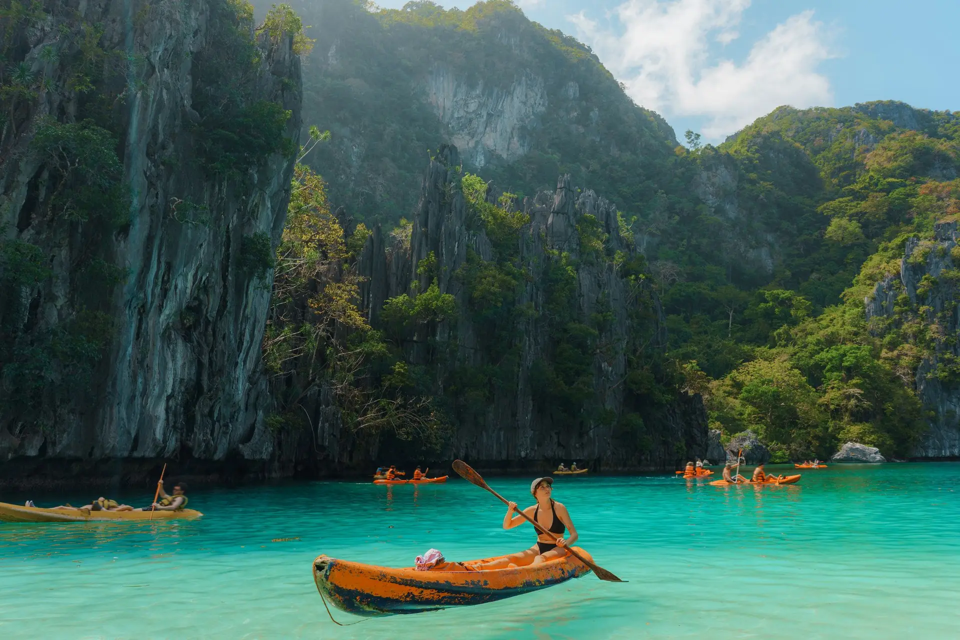 Carefree woman kayaking on El Nido, Philippines.
