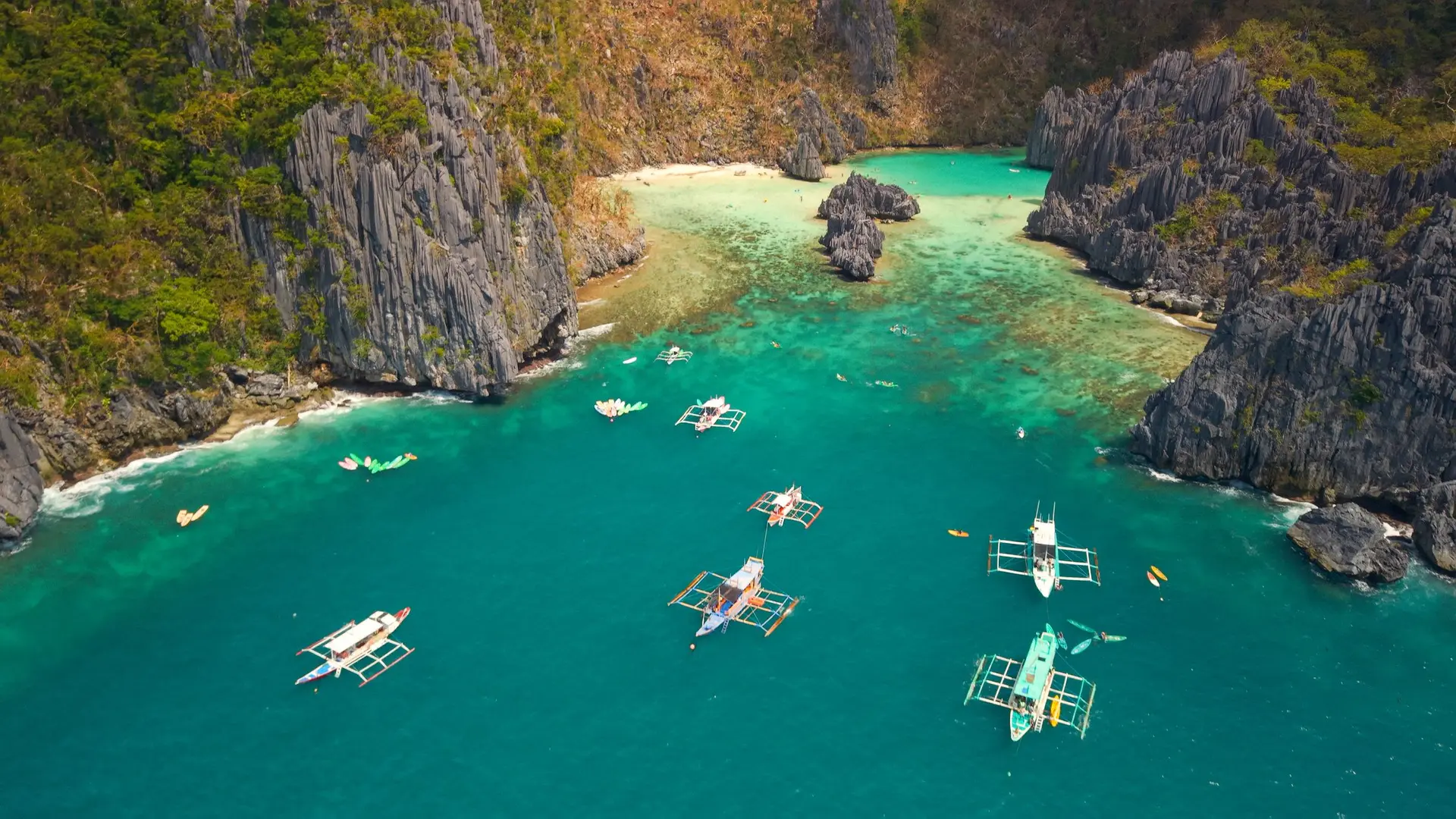 Kayaks and small boats line the waters of El Nido Palawan in the Philippines.